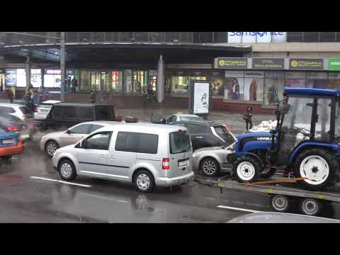 Volkswagen Caddy в центре Киева с трактором на прицепе