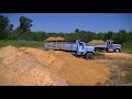 GMC and International Dump Trucks Dumping Sand