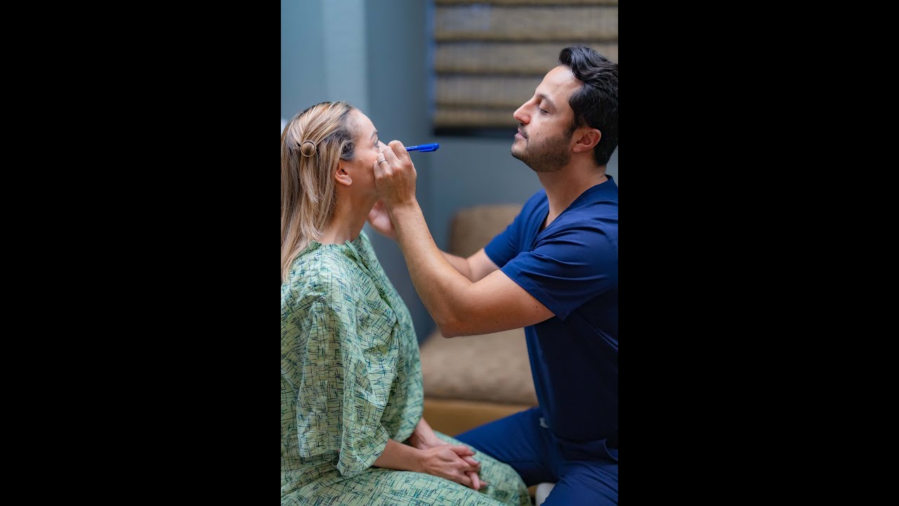 Professional applying makeup in a clinic setting.