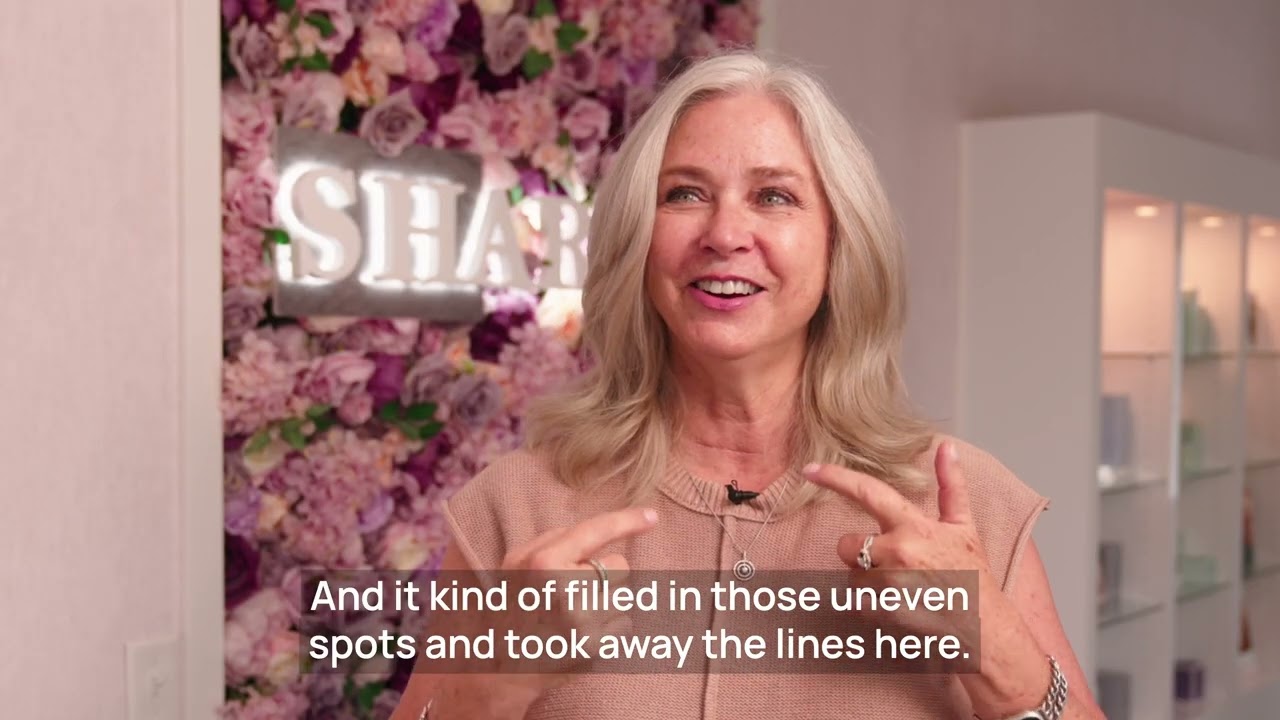 Woman discussing skincare benefits with floral background.