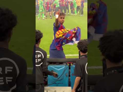 Lamine Yamal cogiendo una bandera del Barça de la grada tras la final de la Supercopa