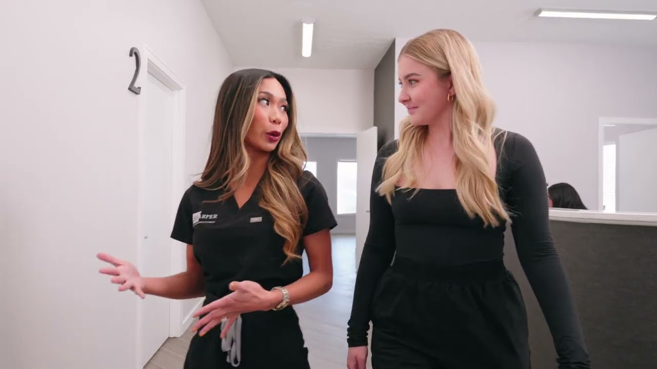 Two women walking and conversing in clinic.