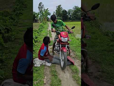 The boy lifted the motorcycle onto the man's feet.