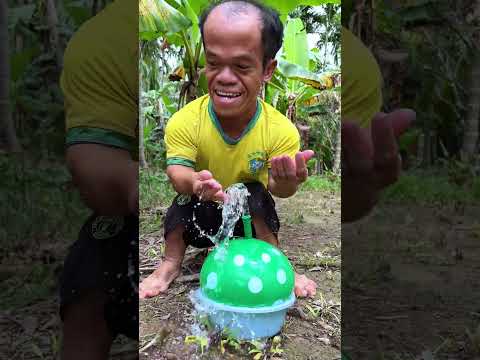 Homeless old man watering plants with balloons is