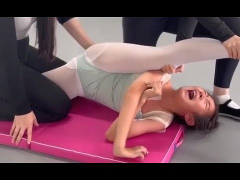 過酷な練習に耐えるバレエ女子 床に股が着くまで押される柔