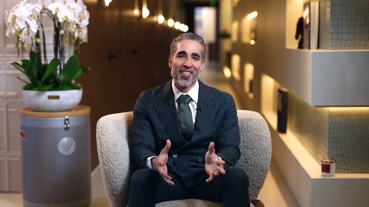 Man smiling while seated in a stylish interior.