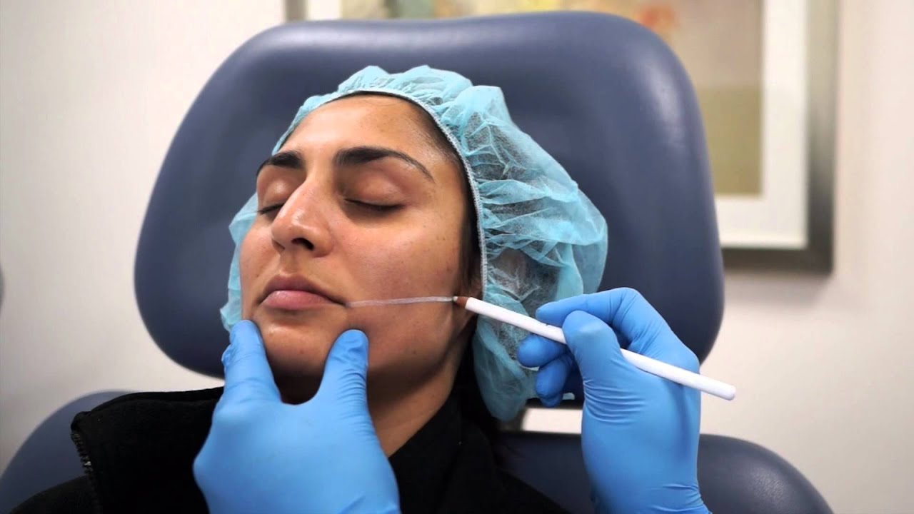 Patient receiving facial treatment in clinic setting.