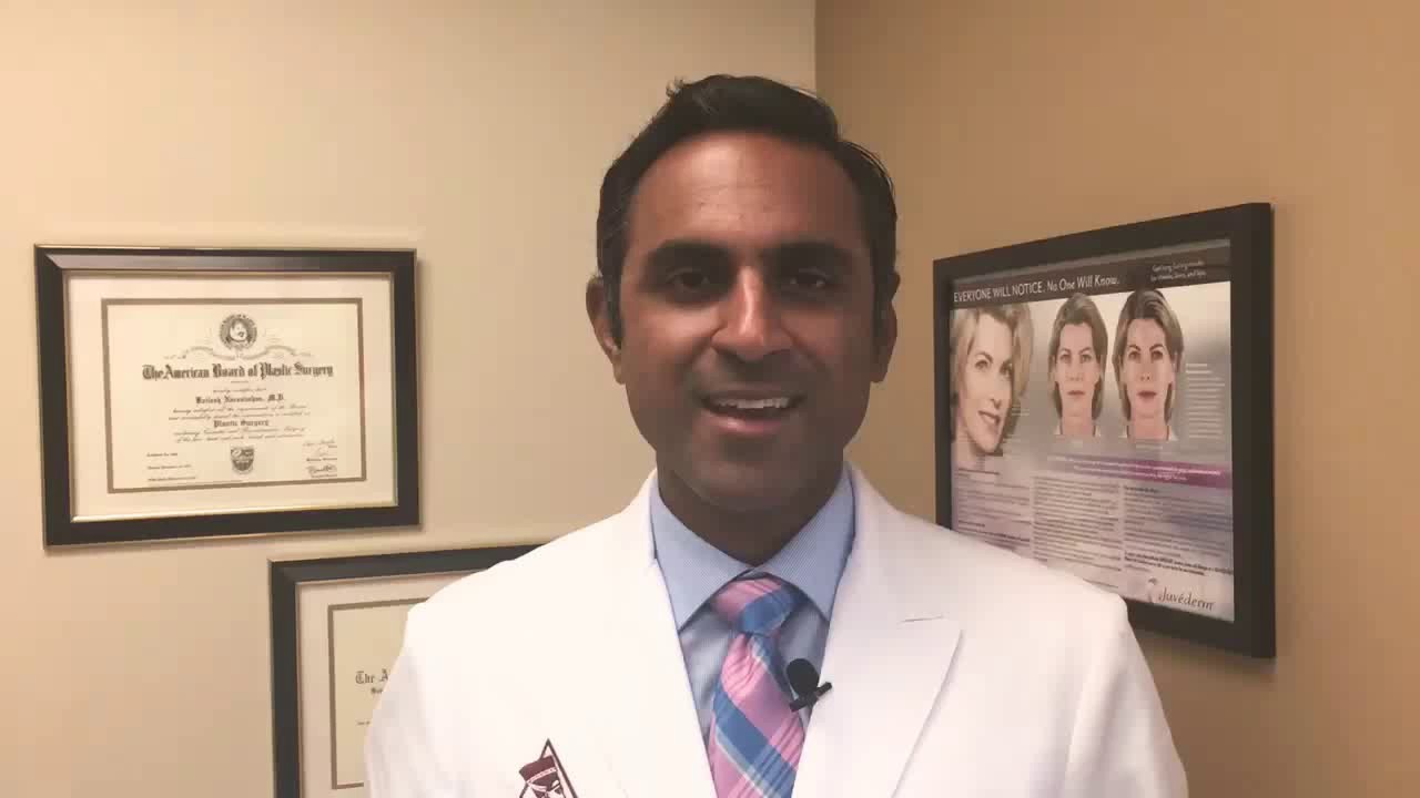 Doctor in white coat smiling in office setting.