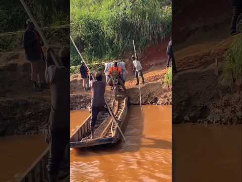 Three motorcycles are crossing the river together on a small wooden boat
