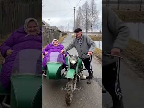 Дед пытается завести стального коня, а бабке весело