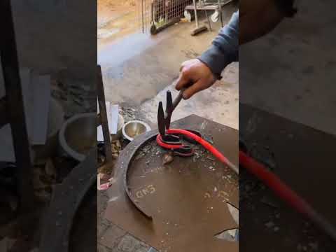 Creating the loop of a Wrap Rake.It's all fire tools and curtain pole Bending up a Leaf Trivet.