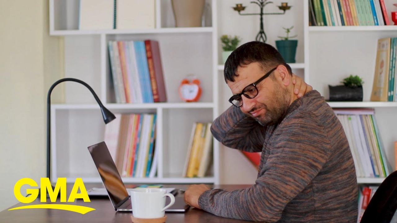 Man with neck pain at desk working.