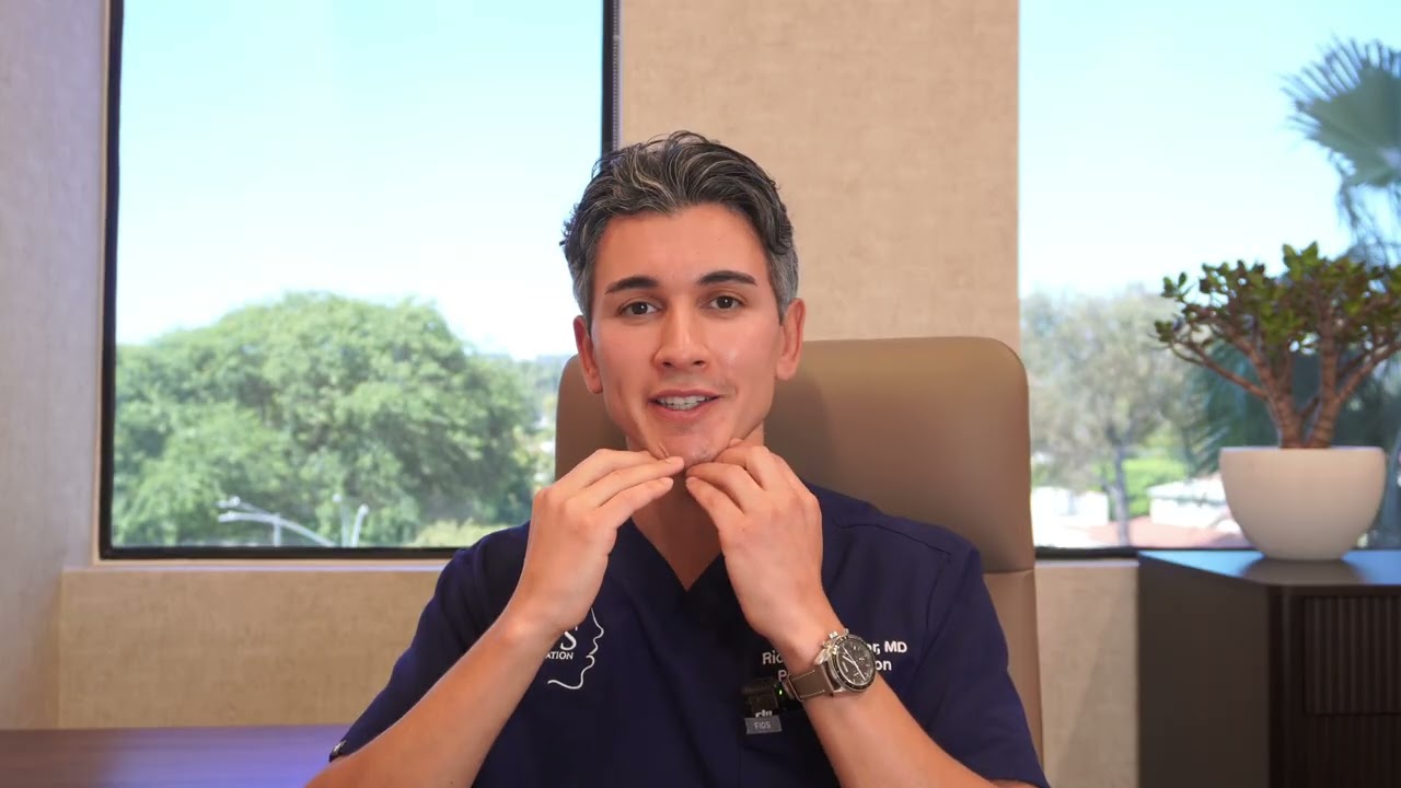 Doctor demonstrating facial techniques in office setting.
