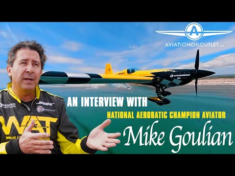 Aerobatic Aviator Mike Goulian alongside his yellow and black plane