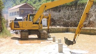 Komatsu PC200 excavator works to dig the harbor to prevent silting.