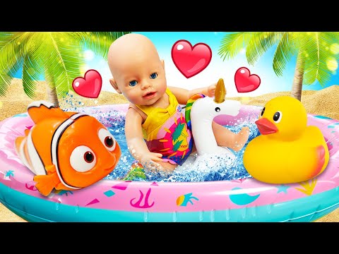 Baby Born nage dans la piscine avec ses jouets de bain. Vidéo avec poupées pour enfants