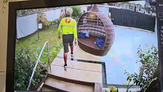 Delivery man protects parcel and sheets from rain in Kingston, Queensland
