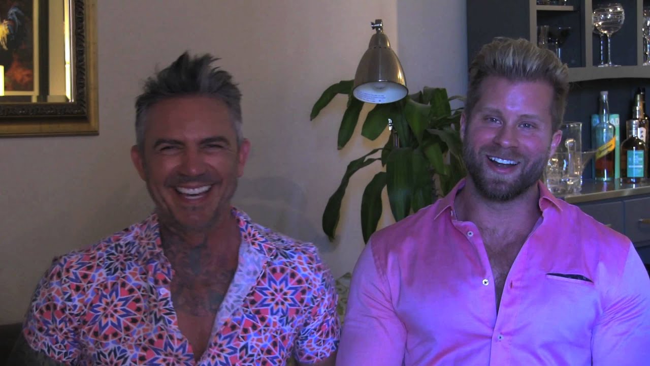 Two smiling men in colorful shirts.