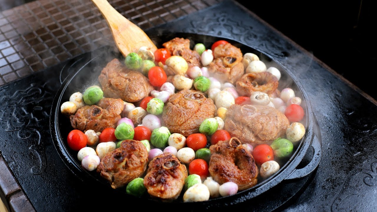 Стейки индейки с овощами в сковороде на огне