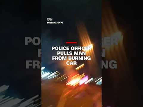 Police officer pulls man out from burning car