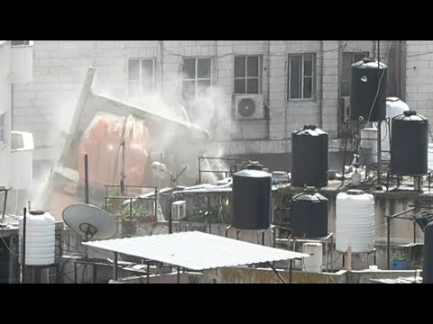 Israeli army excavator demolishes building in West Bank's Nur Shams | AFP