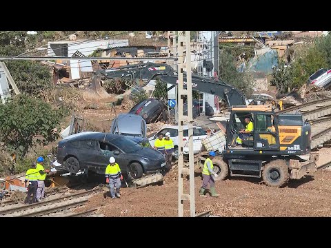 Workers remove cars littered across train tracks in Valencia flood-hit area | AFP