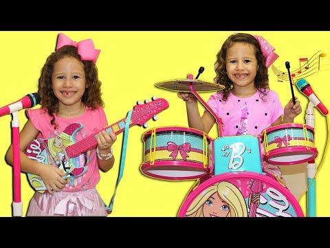 Valentina plays with a toy battery and Disney guitar  and starts a band complete