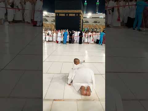 The father is praying in front of the Kaaba and the little boy is happily patting his father's back۔