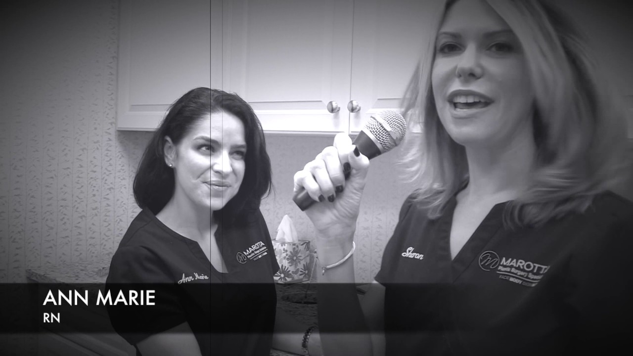 Two nurses in a medical setting, one with microphone.