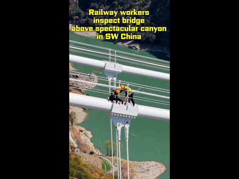 Railway workers inspect bridge above spectacular canyon in SW China