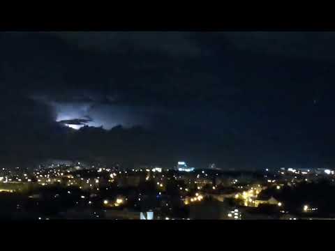 Intenzivní bouře za městem v dáli bez slyšitelných hromů