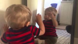 Baby plays with a mirror
