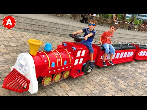 Les Enfants Jouent au Parc d'Attractions et Conduisent les Voitures