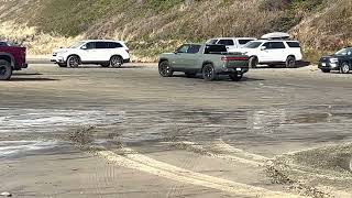 Rivian R1T playing at the beach