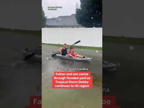 Father and son canoe through yard during Tropical Storm Debby #shorts