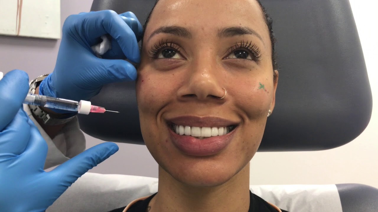 Patient receiving facial treatment in clinic setting.