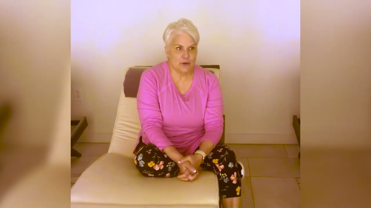 Woman sitting on a chair, looking thoughtfully.