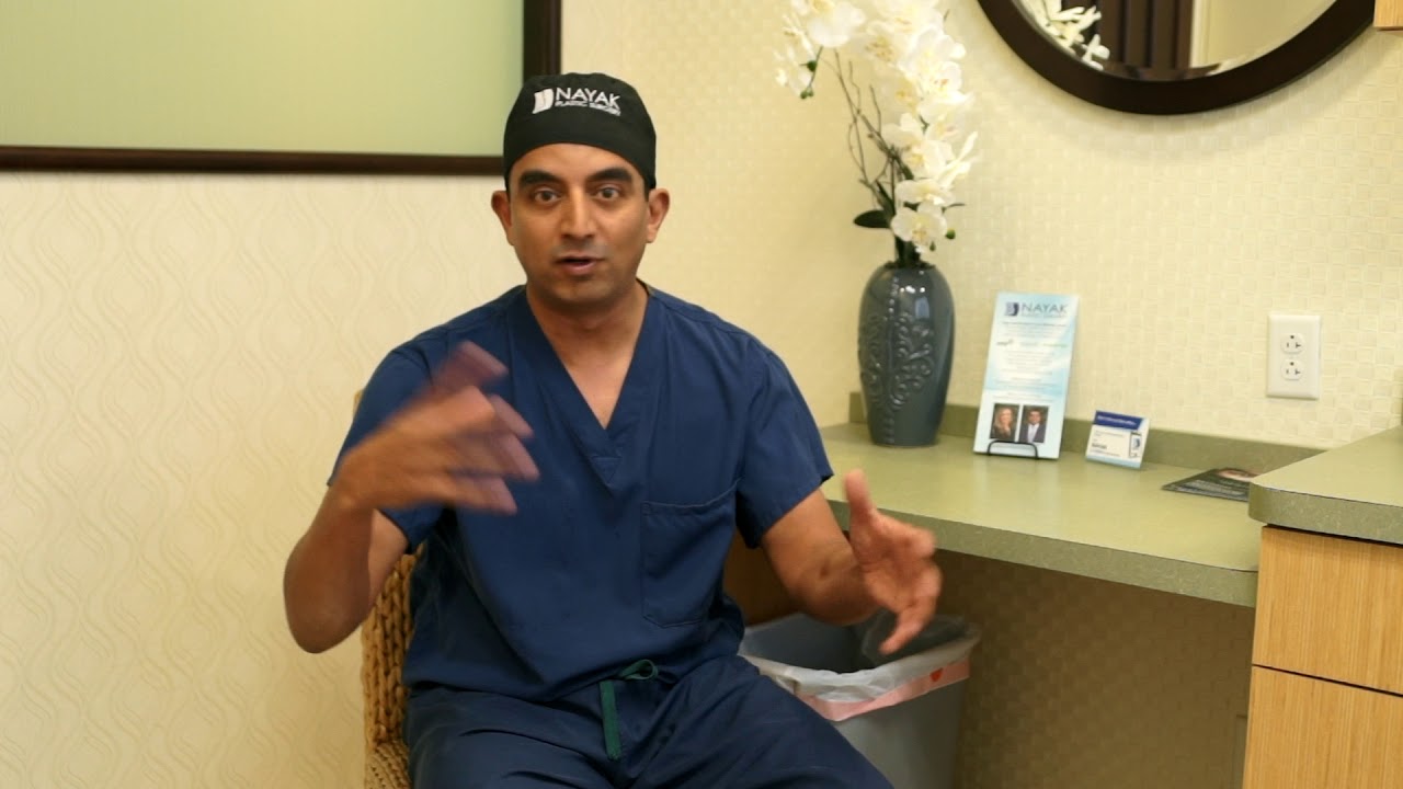 Doctor gesturing while speaking in an office.