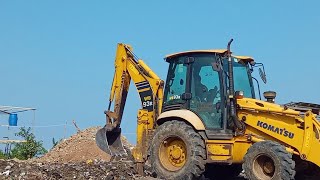 Komatsu Backhoe Loader WB93 R is dredging sand to make a pond.