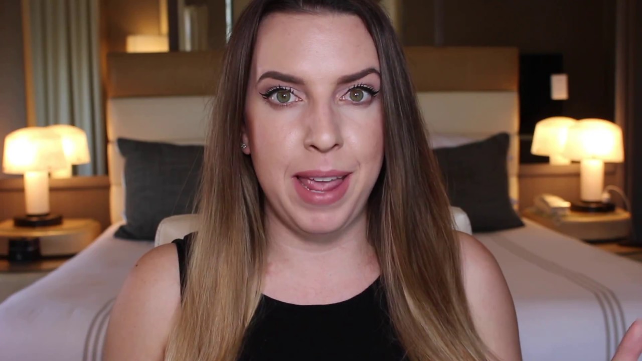 Woman speaking in a hotel room setting.