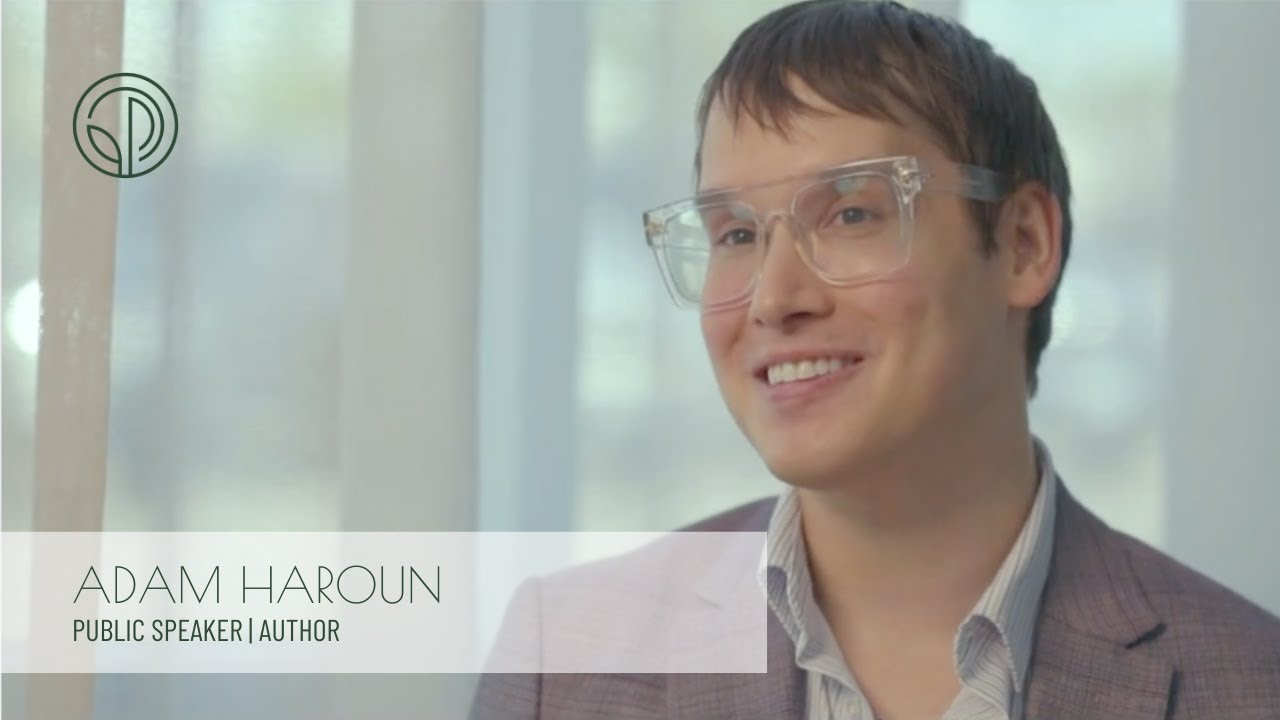 Smiling man in glasses, dressed in a suit.