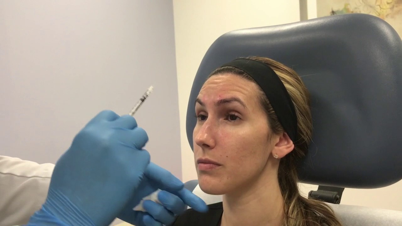Patient receiving facial treatment in clinic setting.