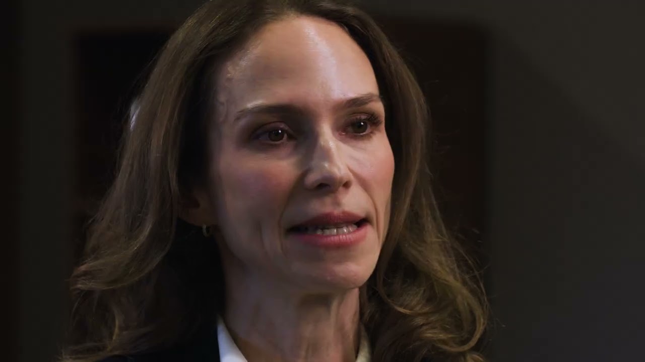 Woman speaking with an intense expression indoors.