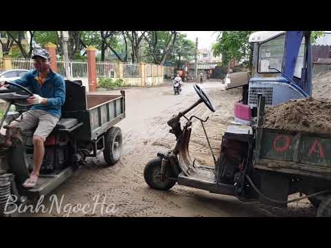 Three-wheeled tractor carrying construction materials