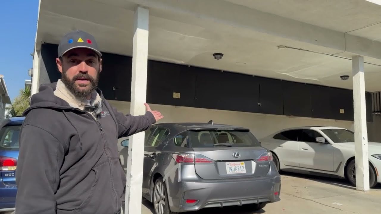 Man pointing at parked cars in parking structure.