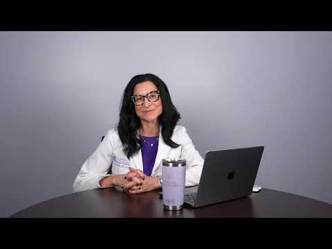 Doctor sitting at a desk with laptop.