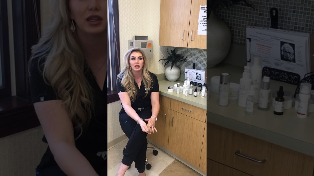Woman discussing skincare products in treatment room.