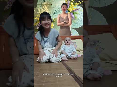 赤ちゃんは座って、お<strong>姉</strong>ちゃんと触れ合っています。