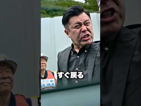 「工事現場の入り口に車を停める外国人」