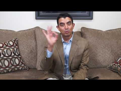 Man sitting on couch making hand gesture.
